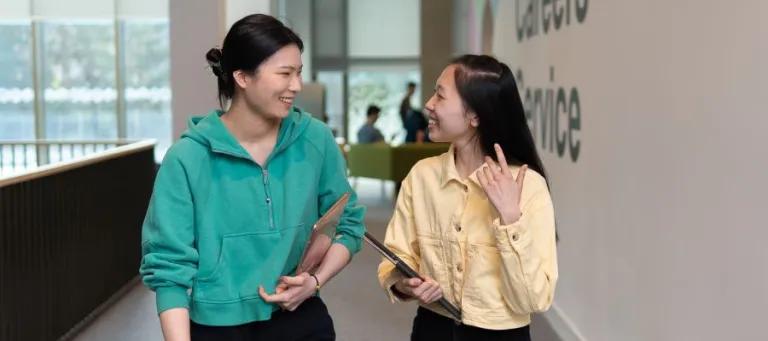 two students talking and smiling 