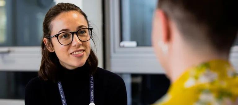 Member of staff listening to a student 